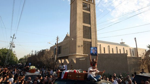 A Missa sangrenta Durante o enterro, fiéis levam a foto do Padre Taher Saadallah Boutros, martirizado durante a missa do domingo 31 de outubro de 2010 junto com dezenas de católicos.